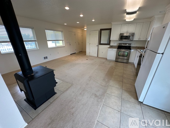 A kitchen with a black stove and white appliances.