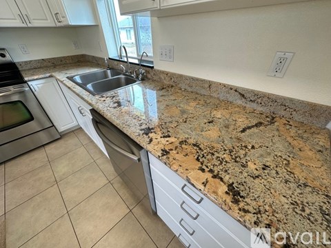A kitchen with granite countertops and white cabinets.