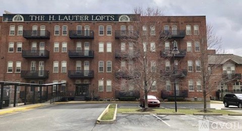 The H. Lauter Lofts is a red brick building with a parking lot in front.