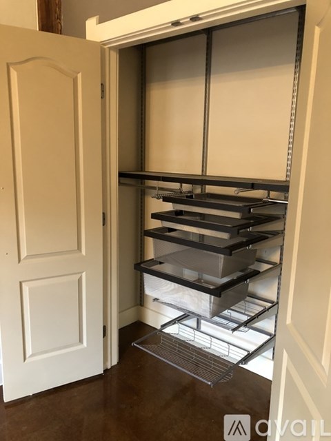 A white door is open to a pantry with shelves and a wire rack.