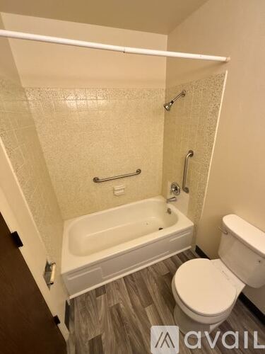 A small bathroom with a toilet, tub, and shower.