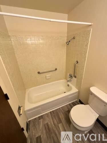 A small bathroom with a toilet, tub, and shower.