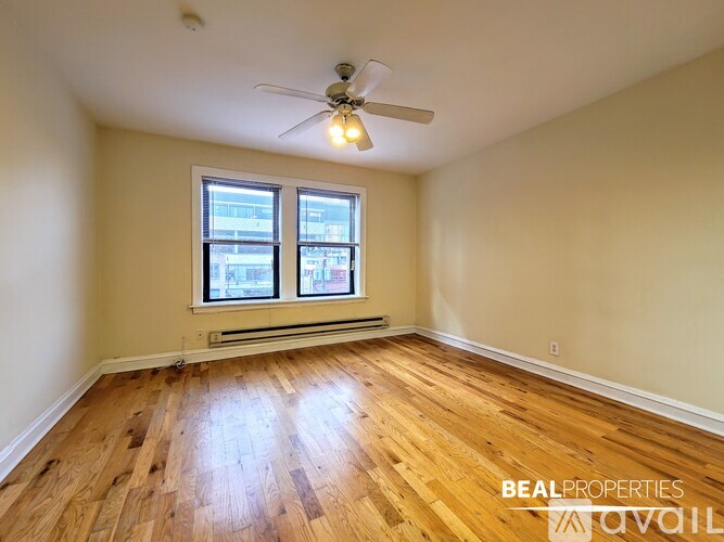 A room with wooden floors and a ceiling fan.