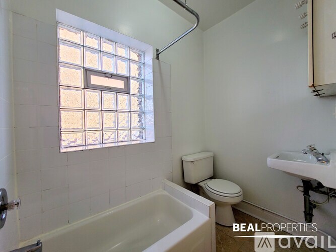 A white bathroom with a toilet, sink, and bathtub.