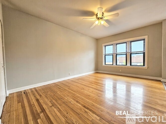 A room with wooden flooring and a ceiling fan.
