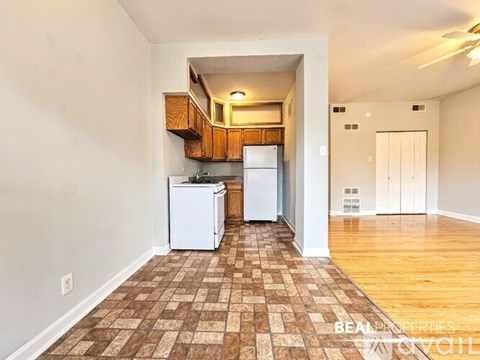 A kitchen with white appliances and wooden cabinets.