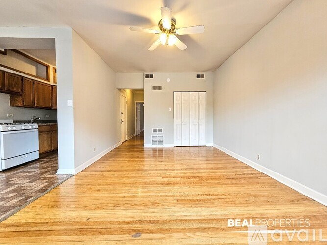 A spacious room with a ceiling fan and wooden flooring.