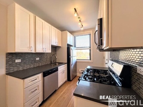 A kitchen with white cabinets and a black stove top.