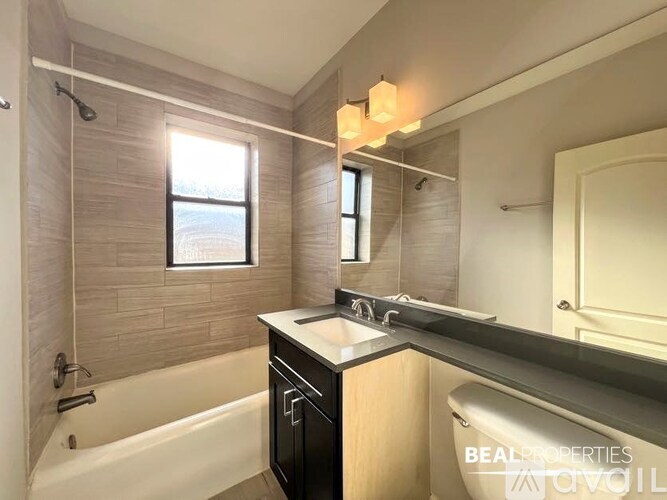 A bathroom with a tub, sink, and mirror.