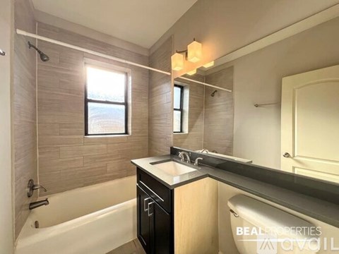 A bathroom with a tub, sink, and mirror.