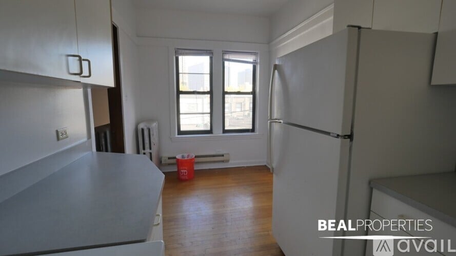 A kitchen with a red bucket on the floor.