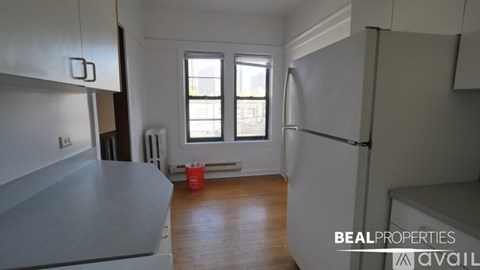 A kitchen with a red bucket on the floor.