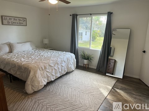 A bedroom with a large bed and a mirror on the wall.
