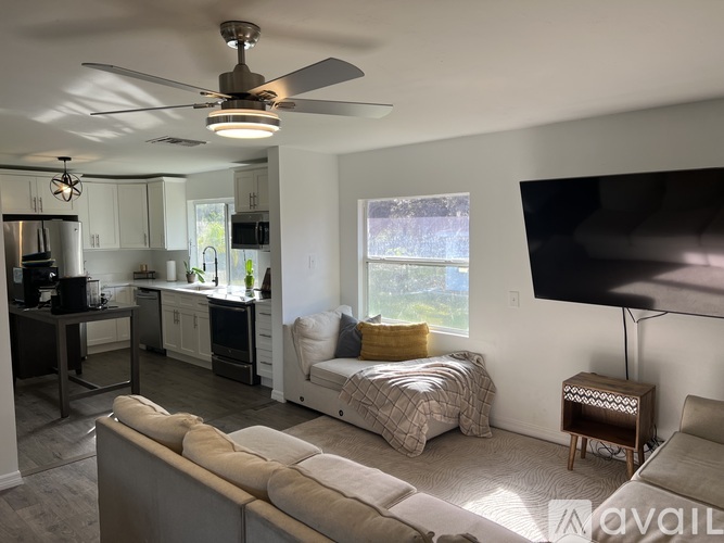 A living room with a grey couch and a ceiling fan.