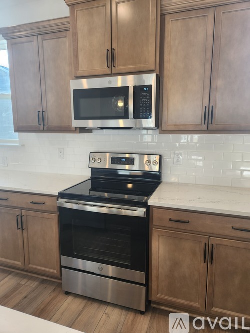A kitchen with wooden cabinets and a stainless steel oven.