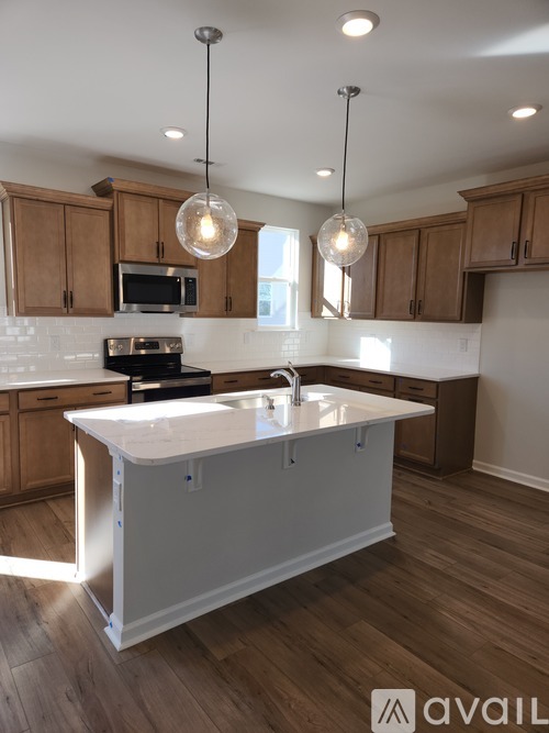 A kitchen with wooden cabinets and a white island.