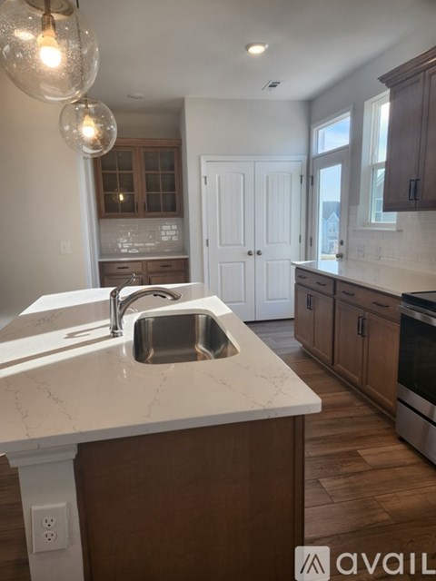 A kitchen with a marble countertop and wooden cabinets.