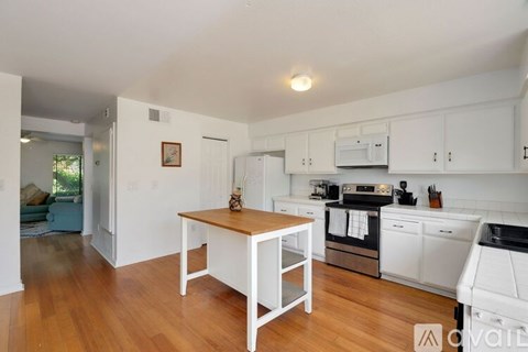 A kitchen with white cabinets and a wooden table.