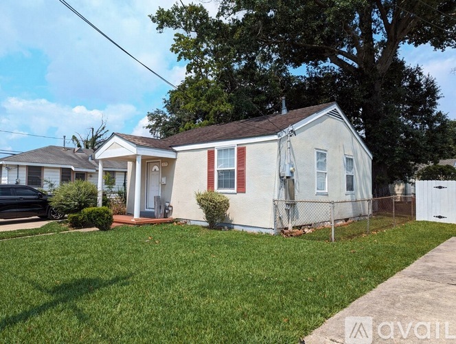 A small house with a white fence in front.