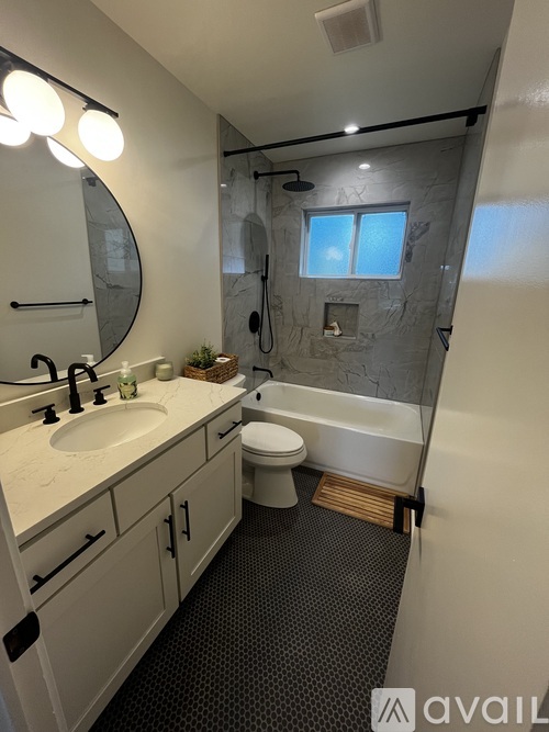 A bathroom with a sink, toilet, and shower.