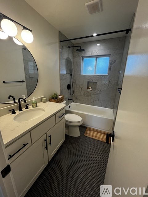A bathroom with a sink, toilet, and shower.