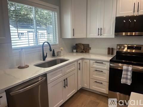 A kitchen with white cabinets and a black stove top oven.