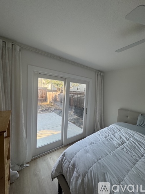 A bedroom with a large bed and a sliding glass door.