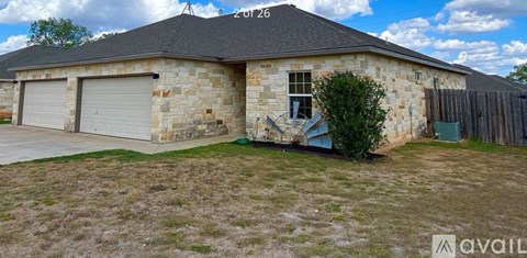A house with a stone exterior and a grey roof.