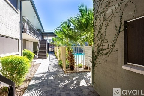 A sunny day at a residential area with a pool and a building with a balcony.