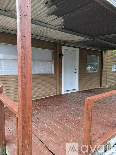 A wooden deck with a white door and a window.