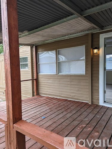 A wooden deck with a bench and a door with a window.