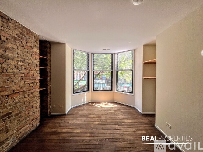 A room with a brick wall and wooden flooring is shown.