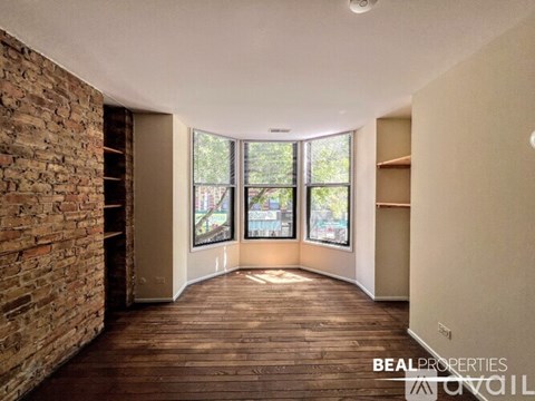 A room with a brick wall and wooden flooring is shown.