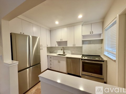 A kitchen with white cabinets and stainless steel appliances.