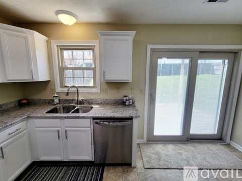 A kitchen with white cabinets and a sink.
