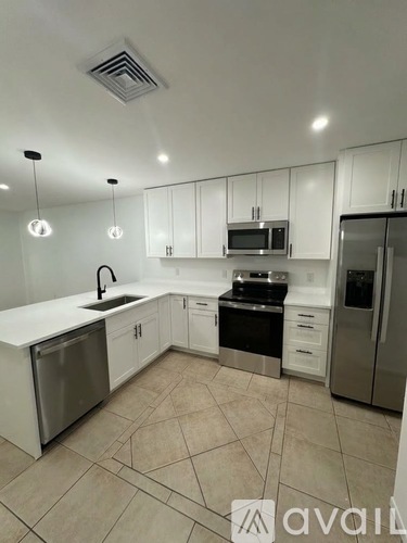 A kitchen with white cabinets and stainless steel appliances.