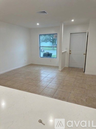 A room with a window and a door is available for rent.