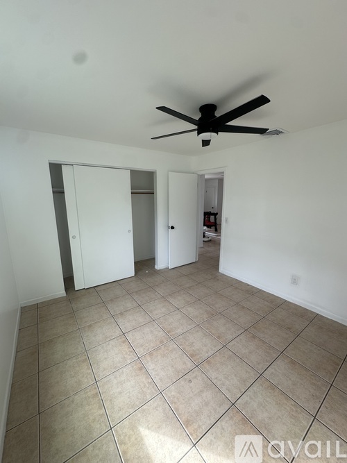 A room with a ceiling fan and tiled flooring.