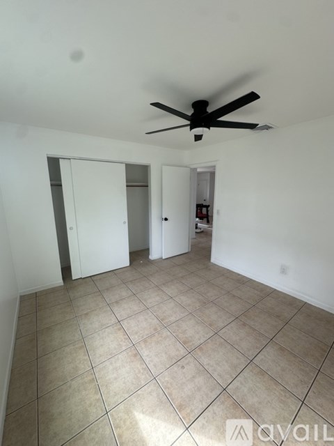 A room with a ceiling fan and tiled flooring.
