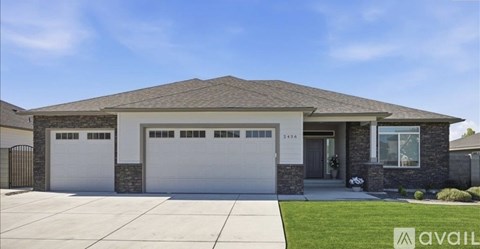 A house with a garage and a driveway in front.