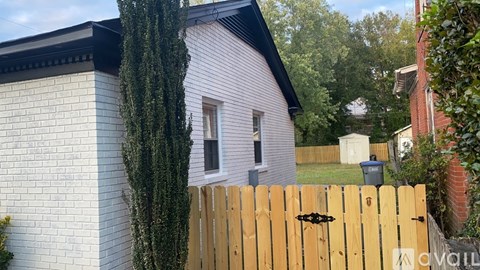 A white house with a wooden fence in front of it.