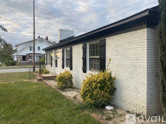 A house with a white brick wall and a black roof.