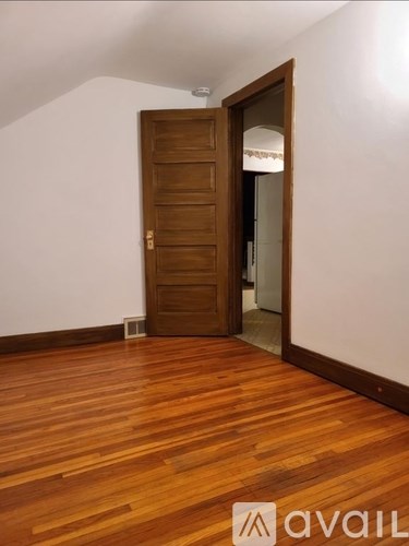 A room with a wooden floor and a brown door.