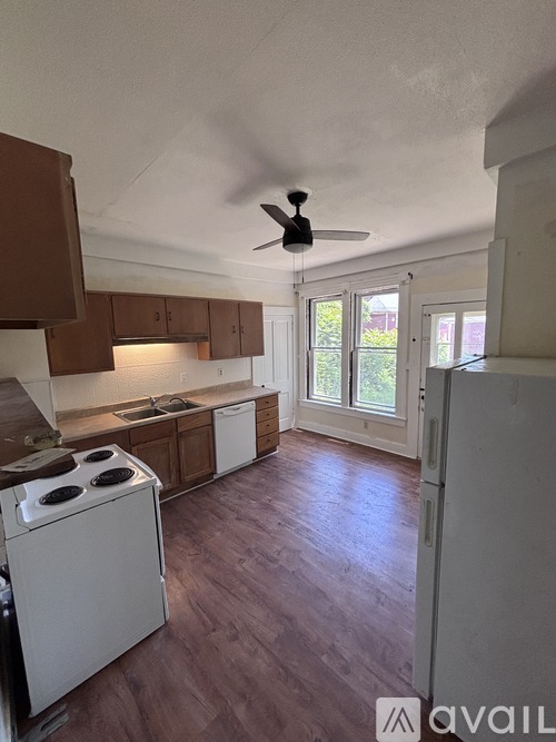 A kitchen with a white stove and wooden cabinets.