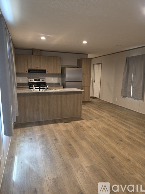 A kitchen with wooden floors and cabinets.