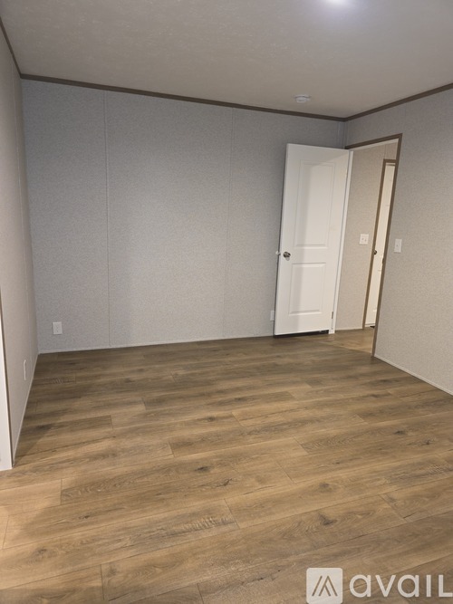 A room with wooden flooring and a white door.