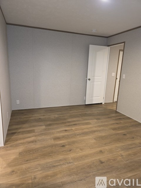 A room with wooden flooring and a white door.