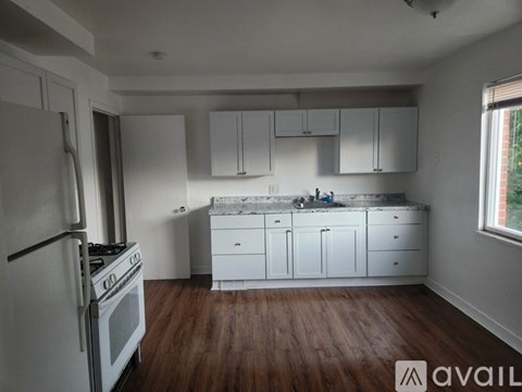 A kitchen with white cabinets and a stove top oven.