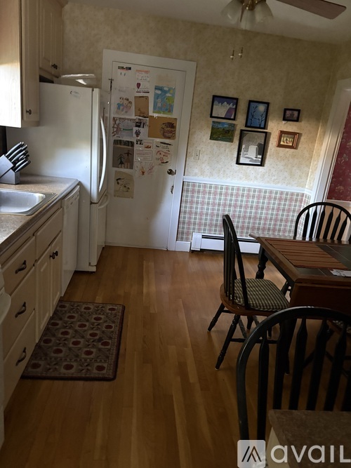 A kitchen with a refrigerator covered in papers and magnets.