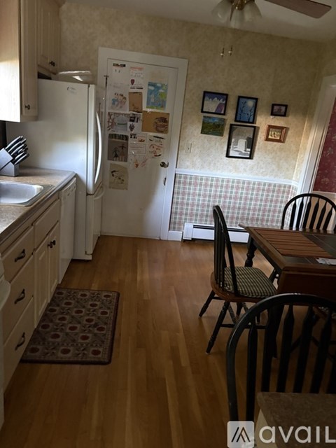 A kitchen with a refrigerator covered in papers and magnets.